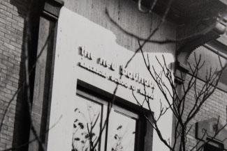 A black-and-white photograph depicts the entrance to a brick building, lined by travertine. Above the front door, a sign reads 'the new bauhaus / AMERICAN SCHOOL OF DESIGN'