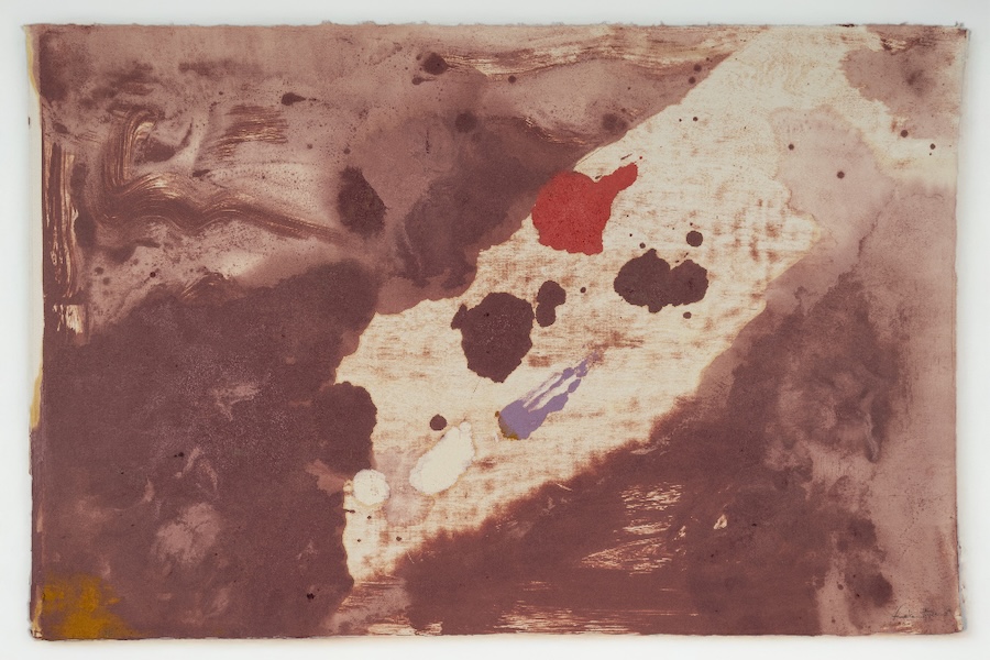 An abstract green circlular shape with blotches of other colors near the edge.