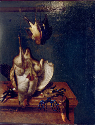 Three dead birds are shown. One small bird with a red mark on its head and black wingtips is laid on its side on top of a brown wooden table. The other two birds are suspended by their legs from a pole above the table with tied string. One of the birds is small and mostly brown, with a white belly. The other bird is much larger than the other two, with a red face, grayish-brown neck and body, and golden-brown wings. It has a large spot of blood on its stomach.