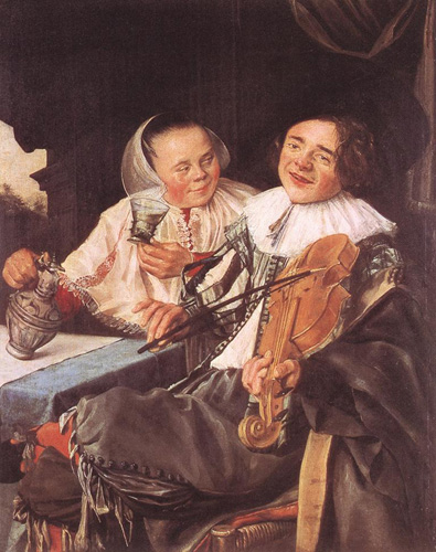 A man and a woman, both with light skin, dark hair, and rosy cheeks are seated together at a table, with the woman turned slightly to look at the man. The woman wears a white shawl and a white cap over her slicked-back hair, and she holds a wineglass in one hand and a silver-colored pot-belly wine jug in the other. The man wears a wide white collar and holds a violin up to his shoulder with one hand, the bow held to its strings with the other.