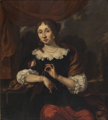 A light-skinned woman with curled brown hair is seated leaning against a table on one elbow. She wears a dress with a black bodice, red skirt, and white sleeves, and has a pearl necklace and earrings. She is playing with of the many bracelets on her wrists and looking directly at the viewer.